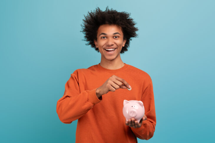 Man putting coins in piggy bank