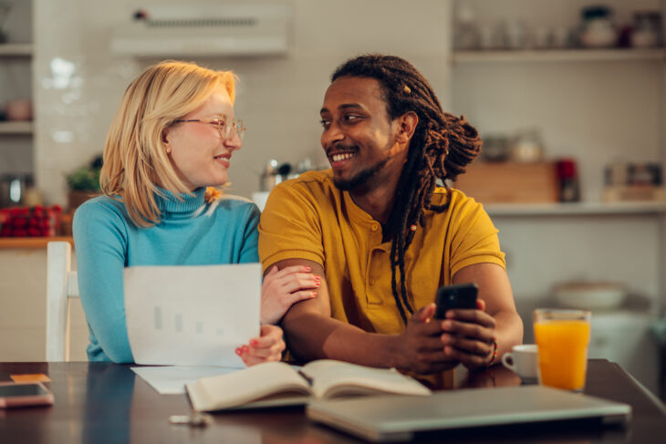 Man and woman sitting at kitchen table together.