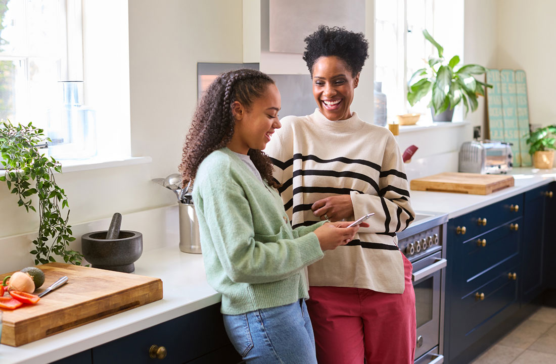 mamá e hija paradas en la cocina