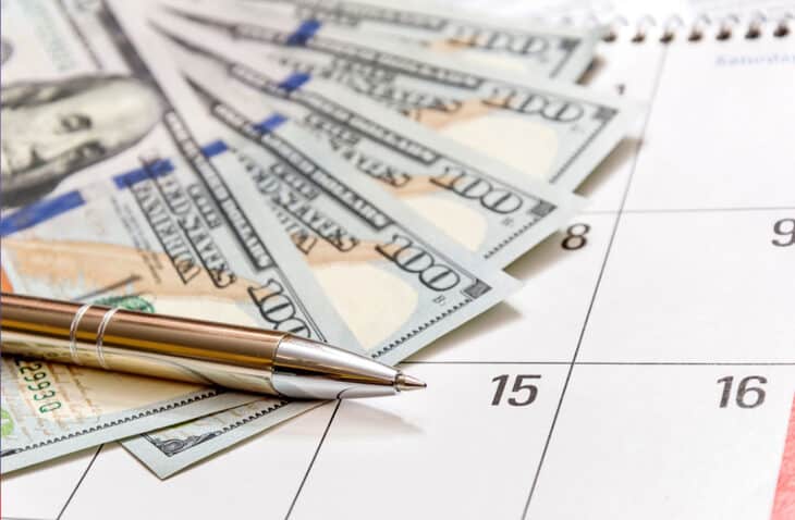 dinero, un calendario y un bolígrafo