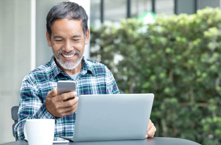 hombre mirando su teléfono y sonriendo