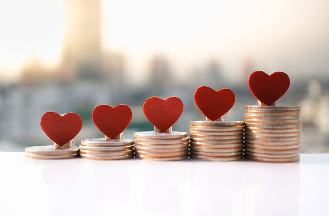 Growing stacks of coins with hearts on top