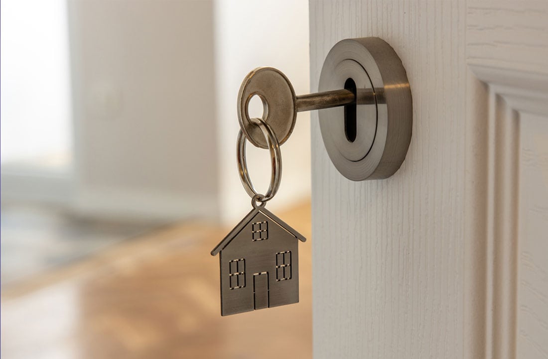 llave con un llavero de casa en una cerradura