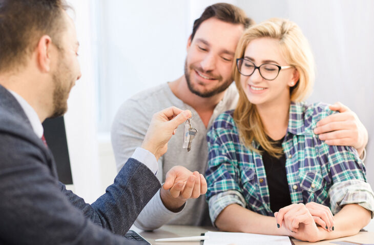 Manager giving key to couple
