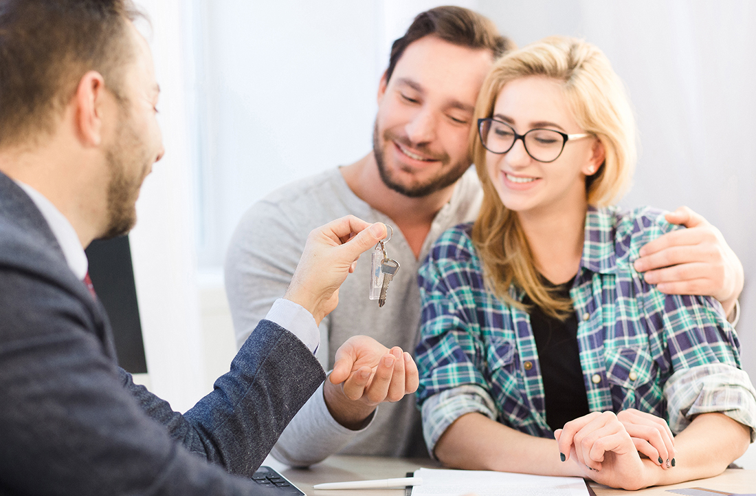 Manager giving key to couple