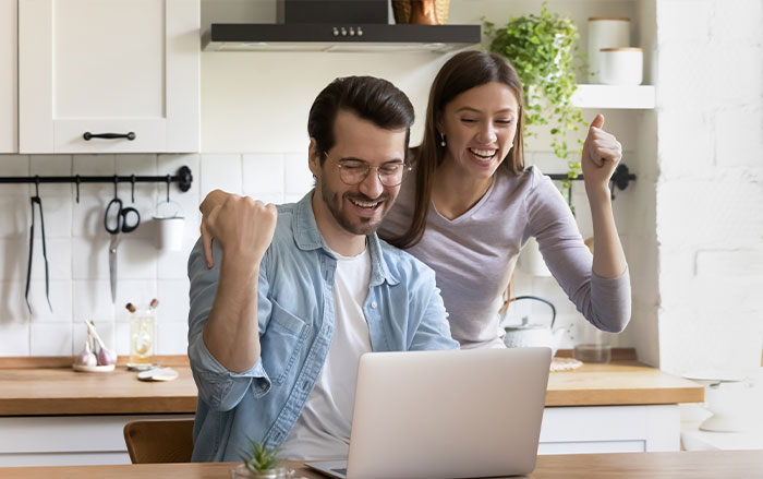 excited couple looking at computer