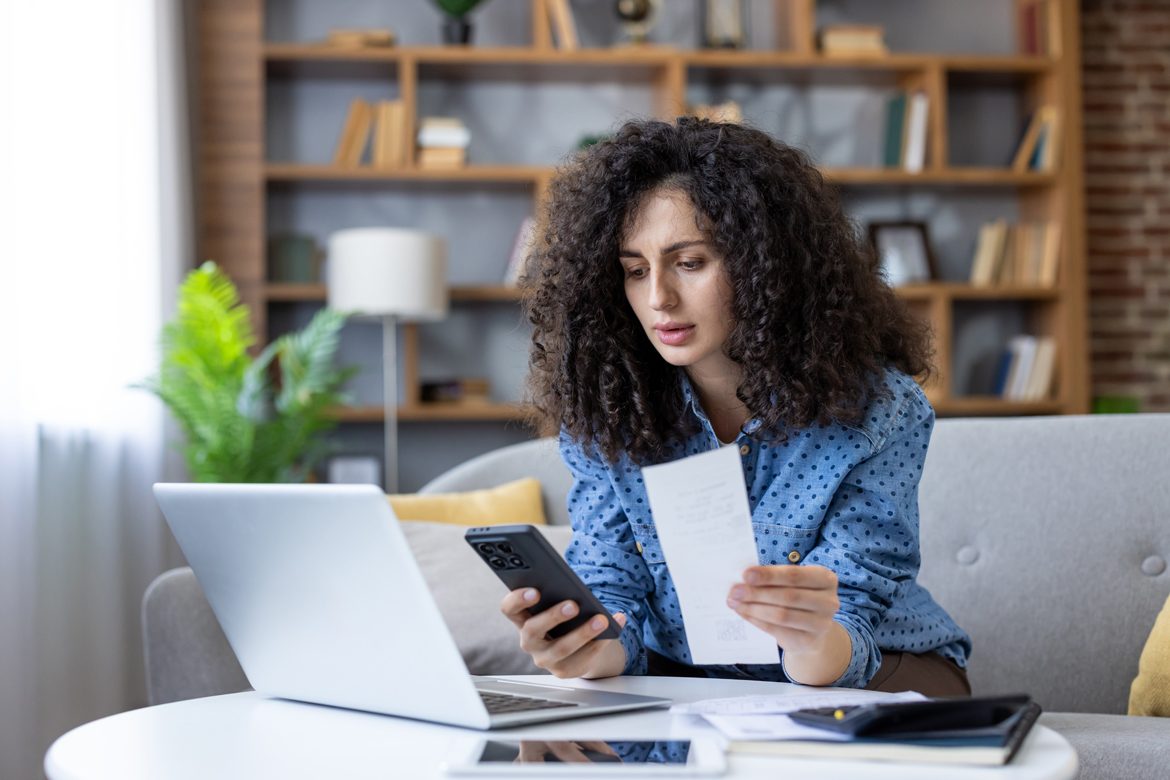 Woman sitting in front of laptop going through finances.