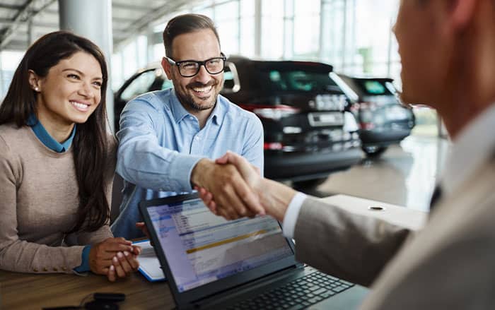 Couple making a deal at dealership