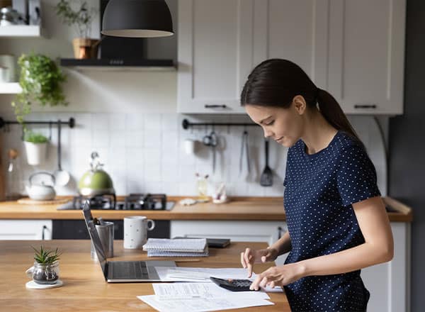 woman standing and using a calculator