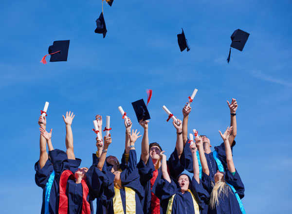 Graduates throwing their caps up