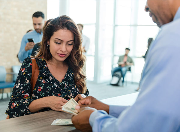 mujer recibiendo dinero en efectivo en un banco