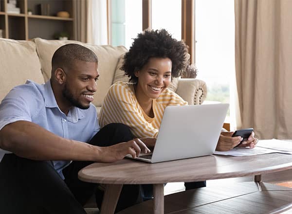 Couple smiling and looking at laptop