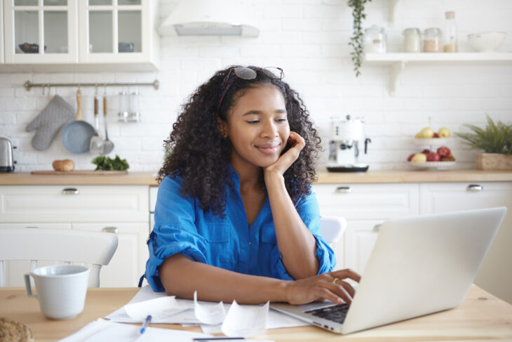 Mujer sonriendo ante la computadora.
