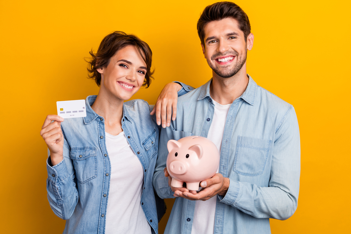 Couple posing holding a piggy bank