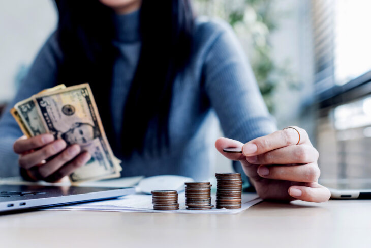 Hands holding cash and counting coins