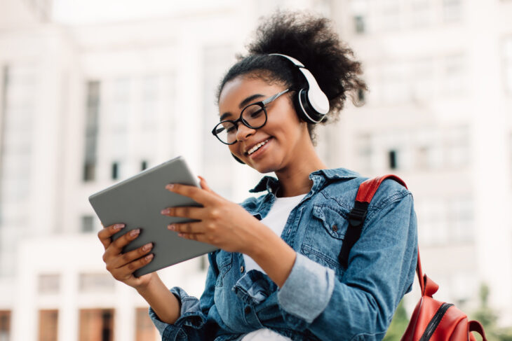 Woman looking at tablet and smiling.