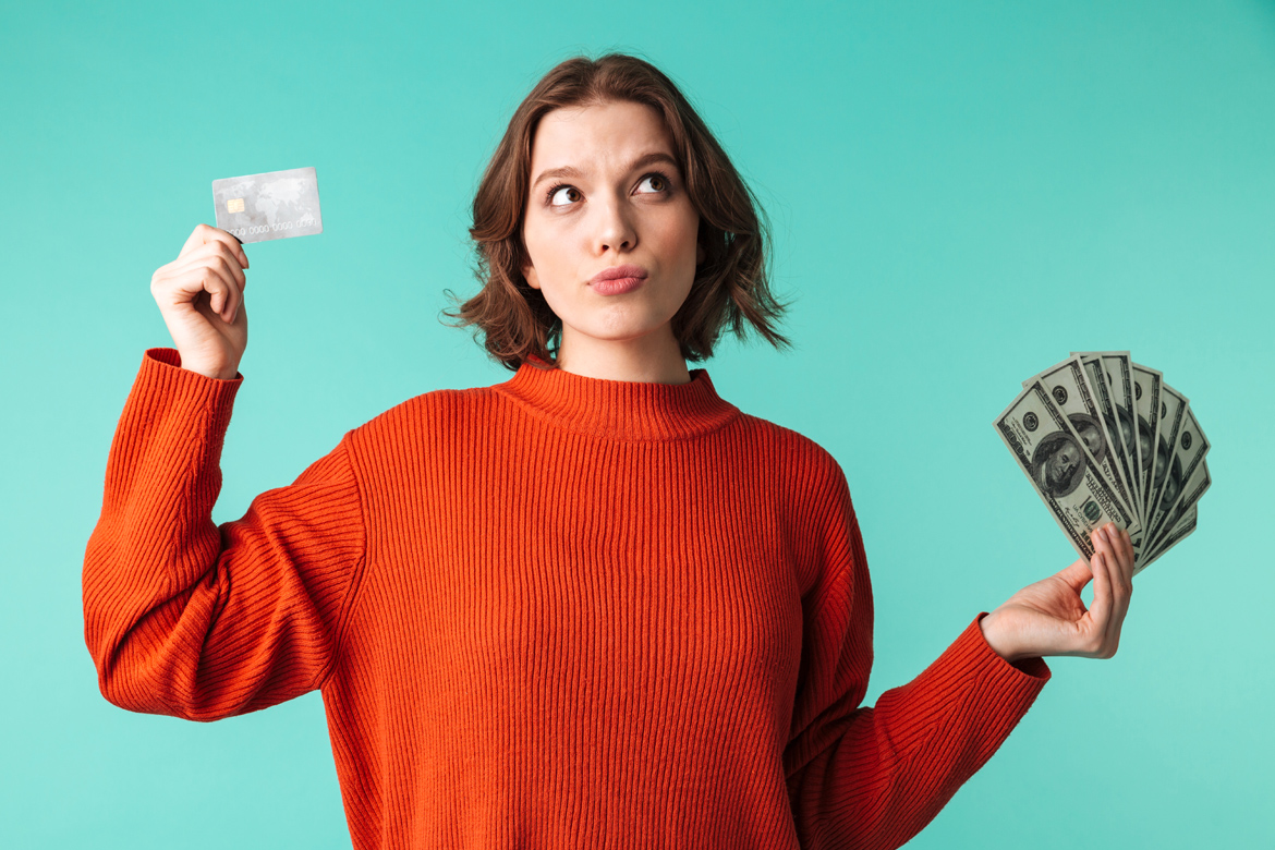 Woman holding debit card and cash