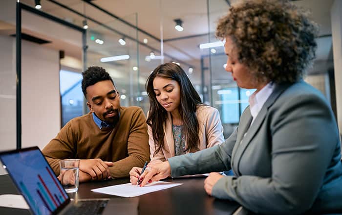 couple with salesperson looking at paper